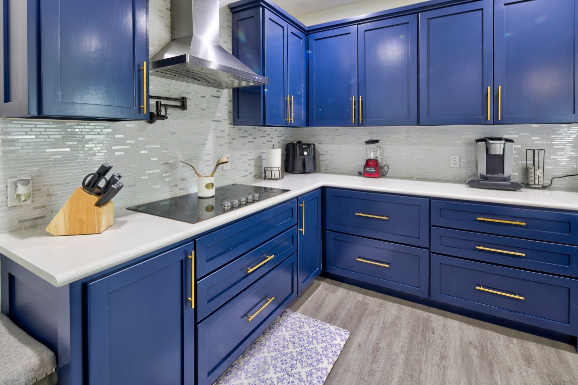 135 Wilbarger Bend Road Bastrop, TX 78602 - Photo 7 of 37 Kitchen with light countertops, wall chimney exhaust hood, and blue cabinets