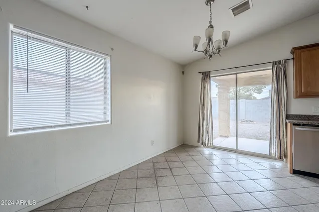 a view of a livingroom with a chandelier fan and windows