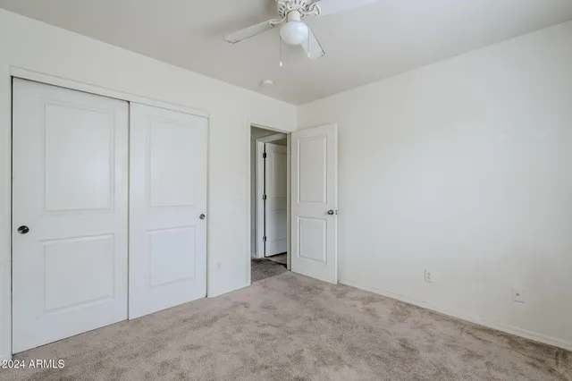 a view of an empty room and a ceiling fan