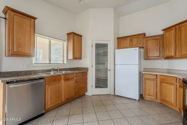 a kitchen with granite countertop a refrigerator and a sink