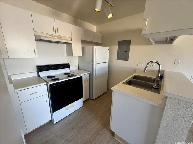 a kitchen with granite countertop a sink stove and refrigerator