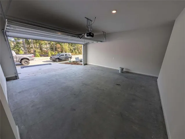 a view of kitchen and empty room with wooden floor