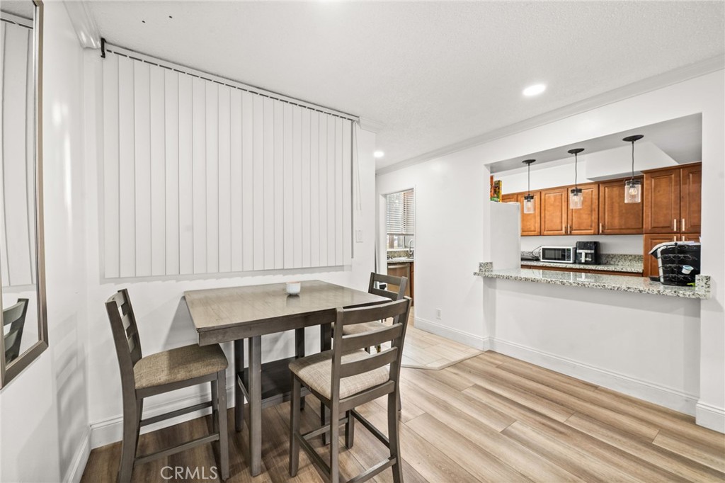 6979 Palm Court, Unit 104A Riverside, CA 92506 - Photo 14 of 53 a kitchen with a table chairs microwave and cabinets