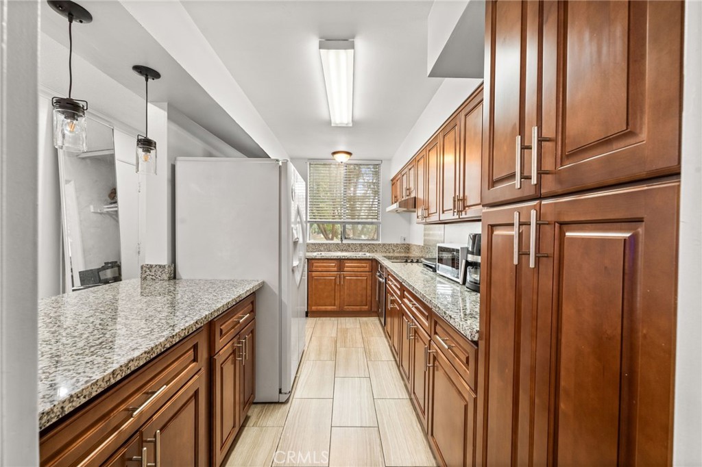 6979 Palm Court, Unit 104A Riverside, CA 92506 - Photo 16 of 53 a kitchen with stainless steel appliances granite countertop lots of counter top space and wooden floor