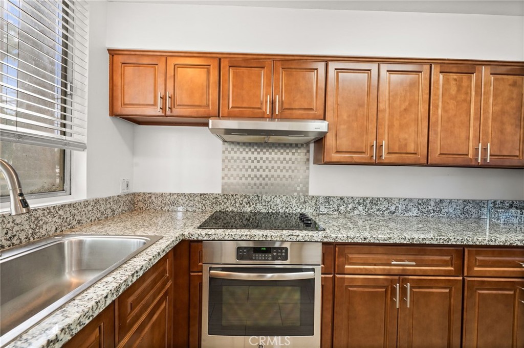 6979 Palm Court, Unit 104A Riverside, CA 92506 - Photo 18 of 53 a kitchen with stainless steel appliances granite countertop a sink stove and cabinets