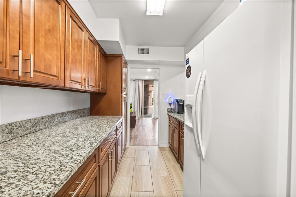 6979 Palm Court, Unit 104A Riverside, CA 92506 - Photo 19 of 53 a kitchen with a refrigerator and countertop
