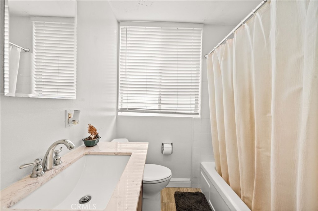 6979 Palm Court, Unit 104A Riverside, CA 92506 - Photo 29 of 53 a bathroom with a sink a toilet and a window