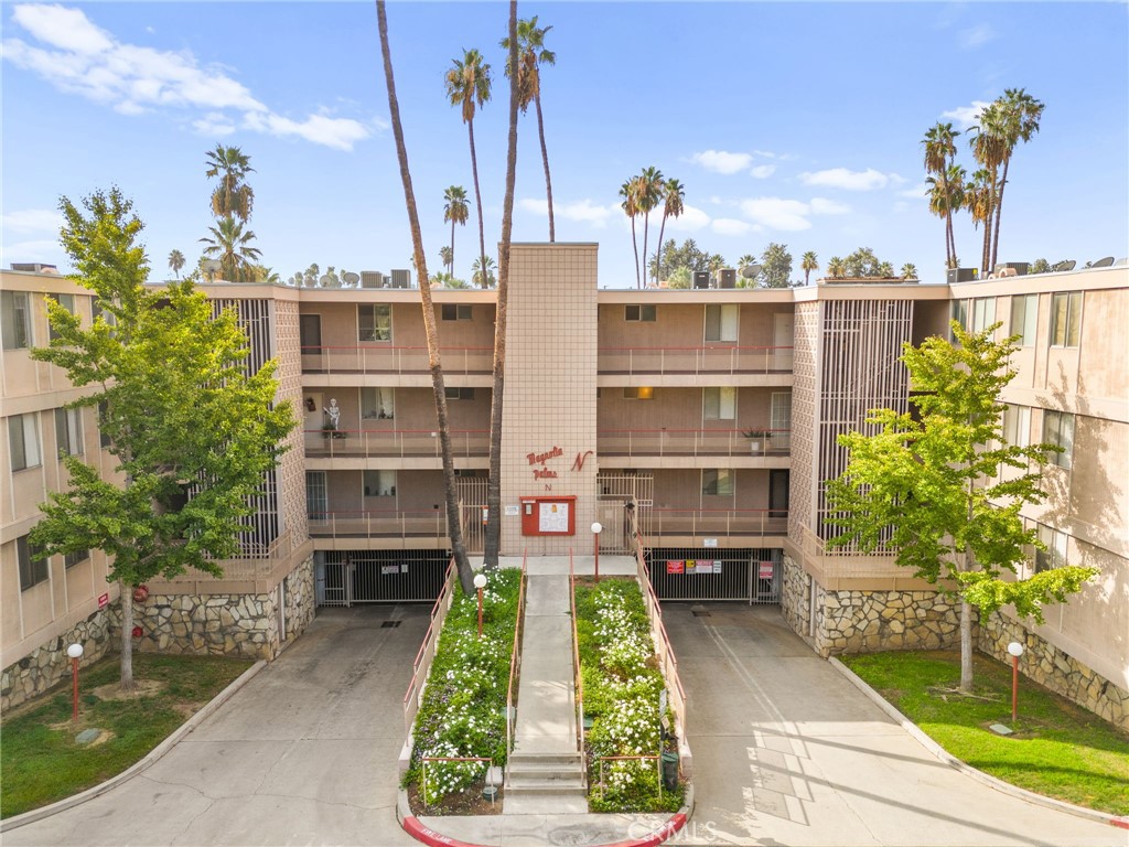6979 Palm Court, Unit 104A Riverside, CA 92506 - Photo 4 of 53 a front view of a house with a garden and trees