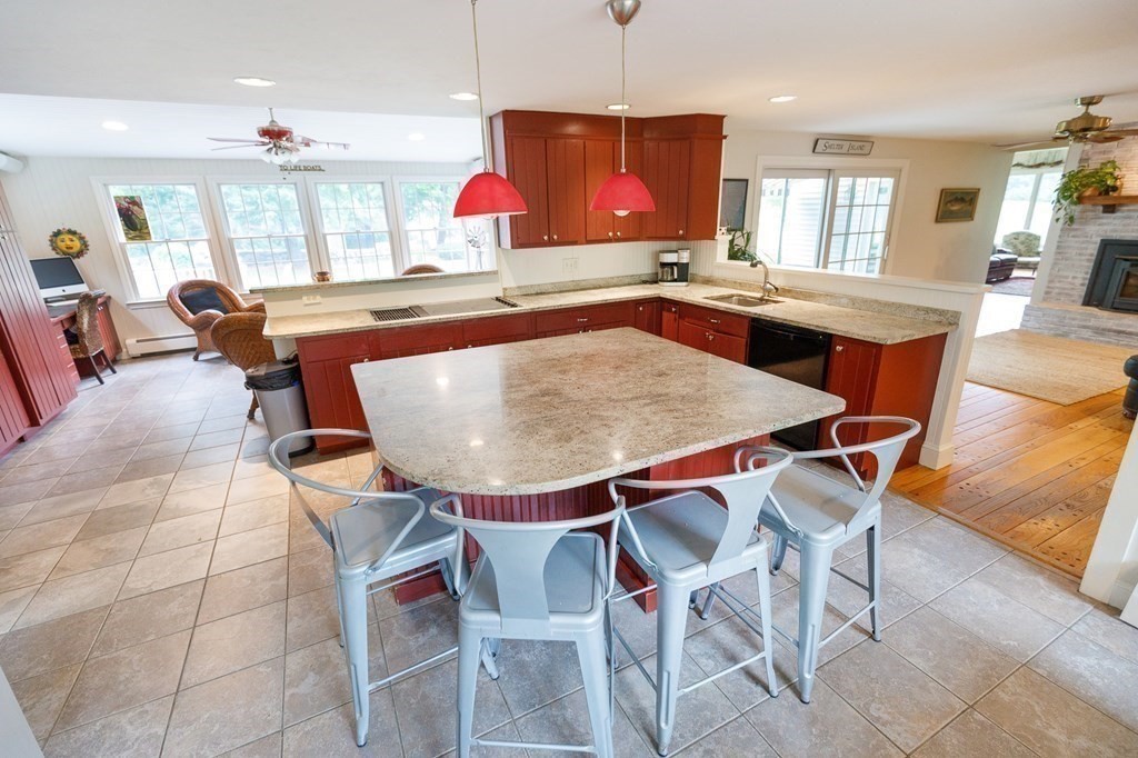 139 Fruit Street Hopkinton, MA 01748 - Photo 8 of 41 a kitchen with stainless steel appliances kitchen island granite countertop a table chairs sink and wooden cabinets