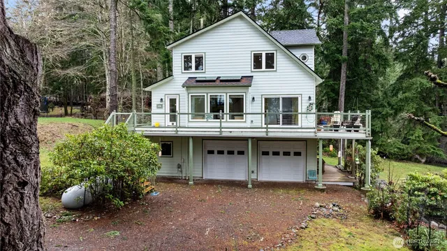 a front view of a house with a garden and trees