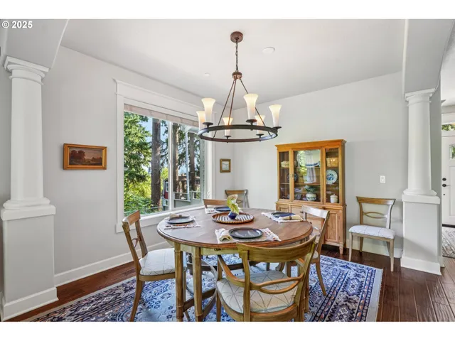 a living room with furniture a fireplace wooden floor and a large window