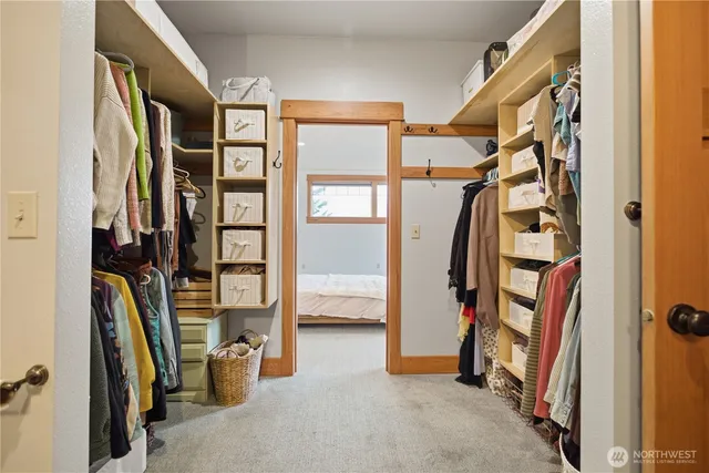 a view of walk in closet with clothes and shoes