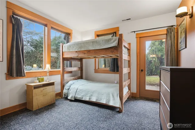 a bedroom with a bed and a flat tv screen next to a window
