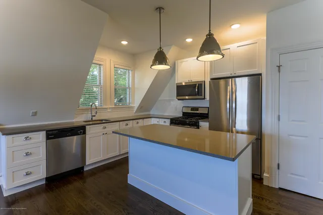 a kitchen with stainless steel appliances granite countertop a sink a stove and a refrigerator