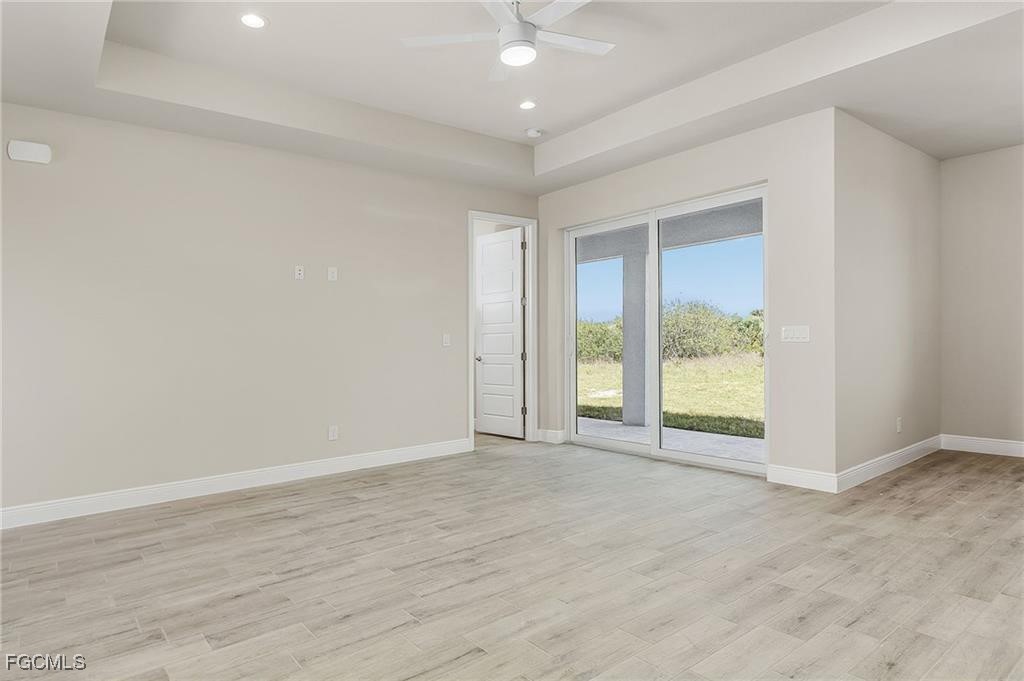 910 Emerald Street LaBelle, FL 33935 - Photo 6 of 19 an empty room with wooden floor and windows
