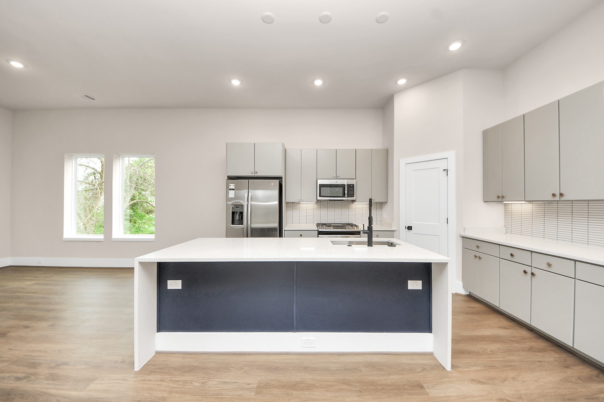 783 Mansfield Street Houston, TX 77091 - Photo 17 of 40 a kitchen with stainless steel appliances a sink a stove a refrigerator cabinets and a center island