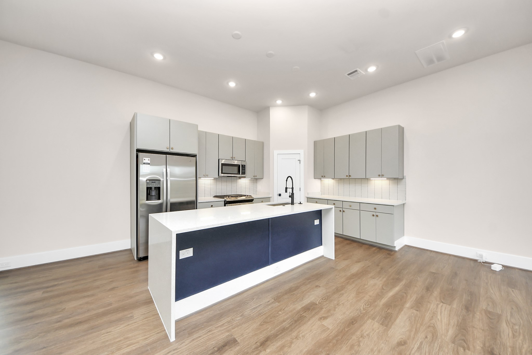 783 Mansfield Street Houston, TX 77091 - Photo 18 of 40 a large kitchen with a center island wooden floor and stainless steel appliances