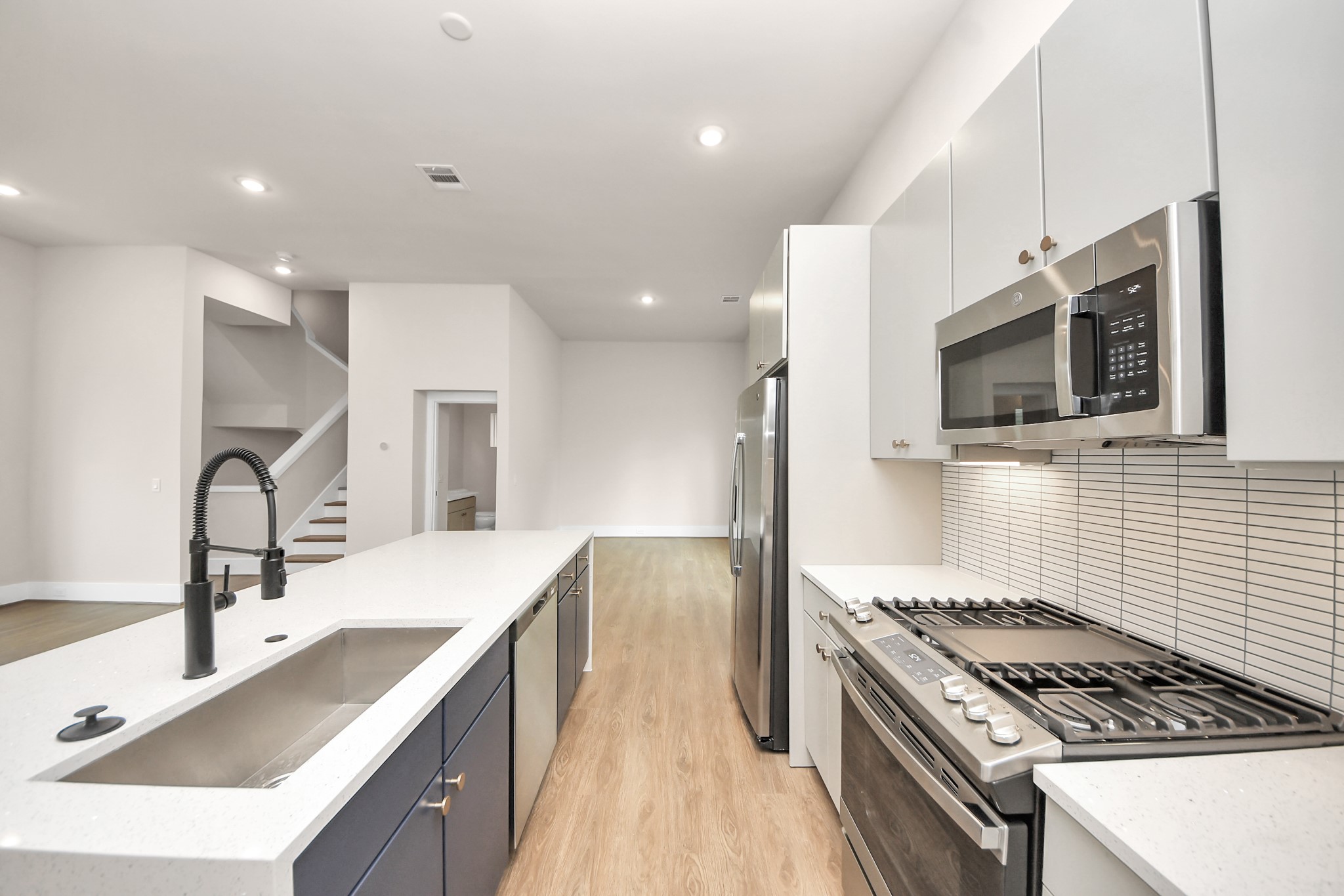 783 Mansfield Street Houston, TX 77091 - Photo 20 of 40 a kitchen with stainless steel appliances kitchen island granite countertop a sink and a stove top oven with wooden floor