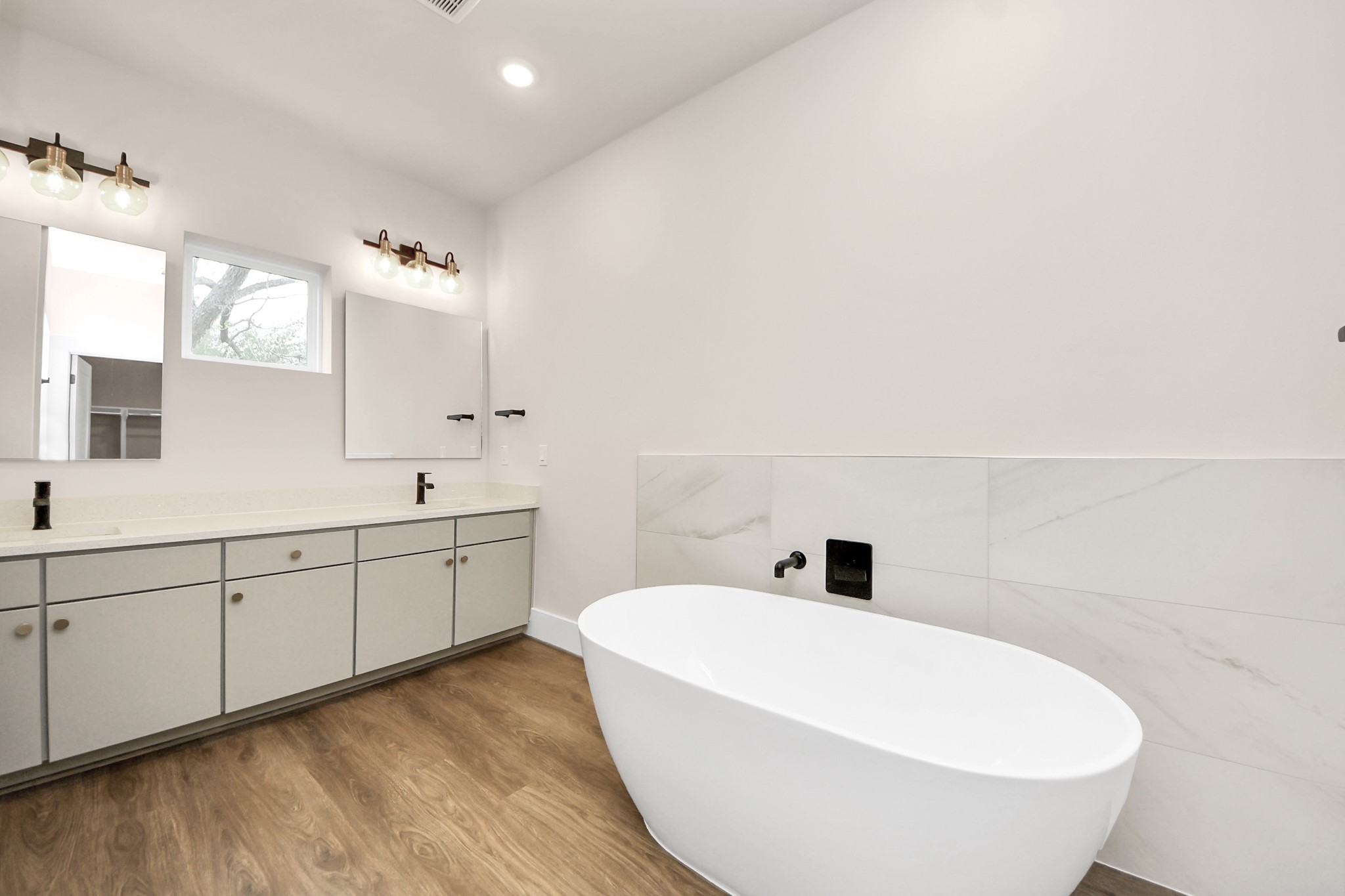 783 Mansfield Street Houston, TX 77091 - Photo 31 of 40 a bathroom with a white tub sink vanity and mirror