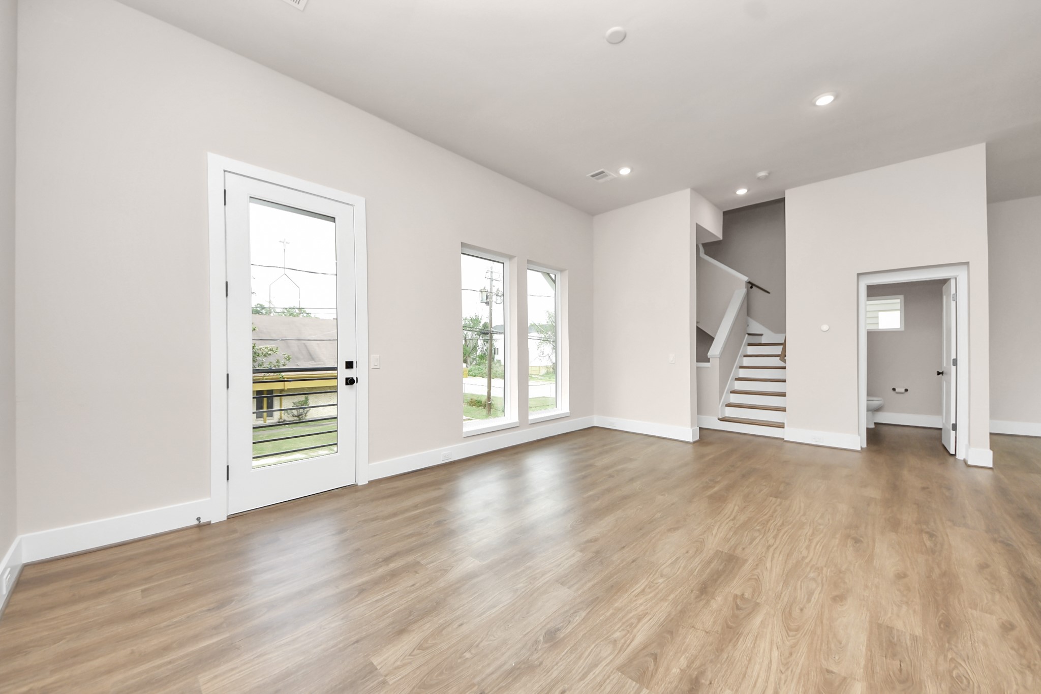 783 Mansfield Street Houston, TX 77091 - Photo 9 of 40 an empty room with wooden floor and windows
