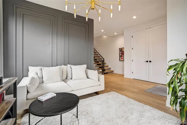 a kitchen with stainless steel appliances kitchen island granite countertop a stove top oven a sink dishwasher a dining table and chairs with wooden floor