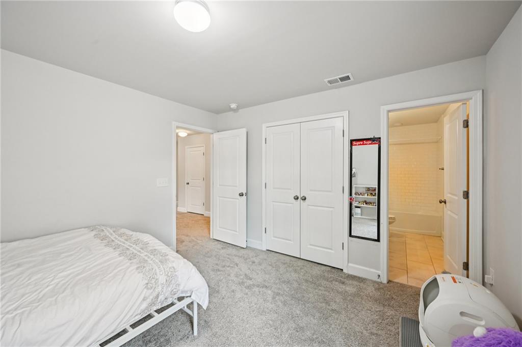 1283 Maston Road Auburn, GA 30011 - Photo 36 of 82 a spacious bedroom with a bed and a couch