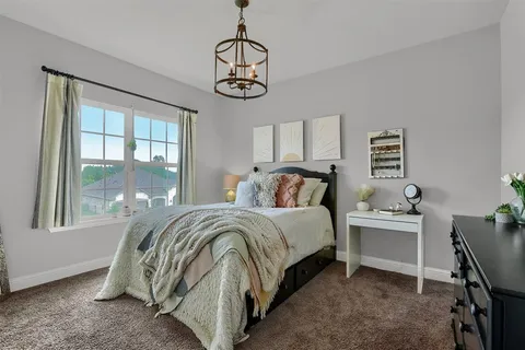 a bedroom with a bed and a chandelier