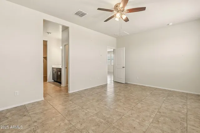 an empty room with closet and a chandelier fan