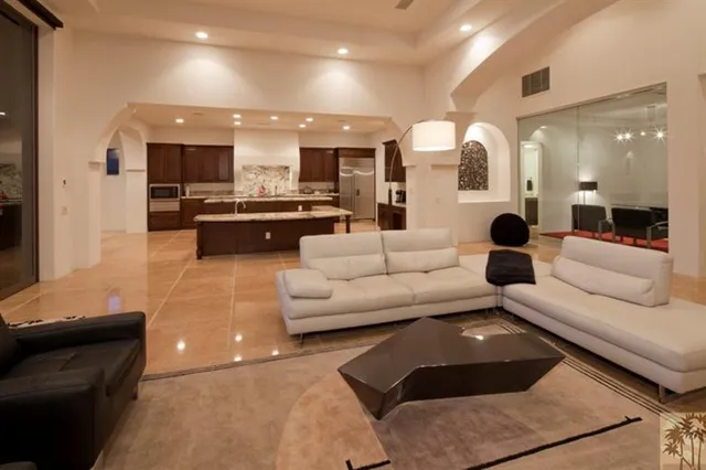 a living room with furniture and view of kitchen