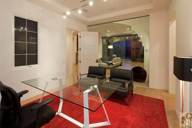 a living room with furniture a clock and white walls