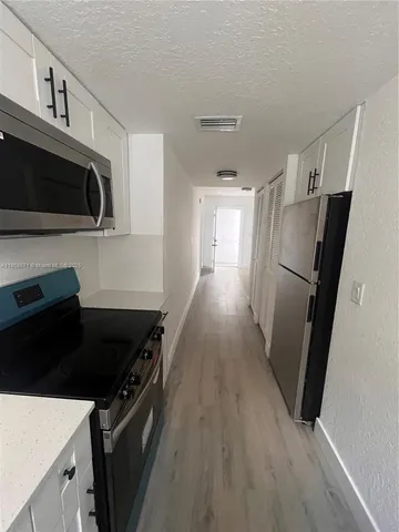 a kitchen with stainless steel appliances a refrigerator and a stove top oven