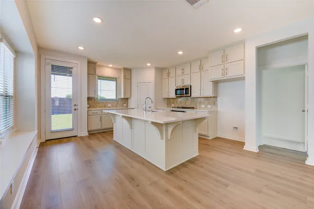 a kitchen with white cabinets and stainless steel appliances