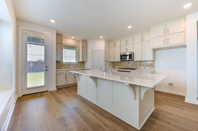 a kitchen with a sink microwave and cabinets