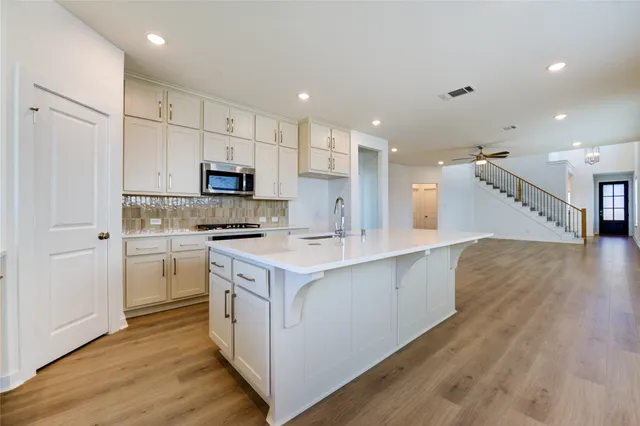 a kitchen with a sink a stove a refrigerator and a microwave