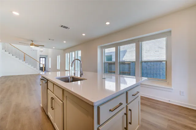 a kitchen with granite countertop a sink and a stove with wooden floor