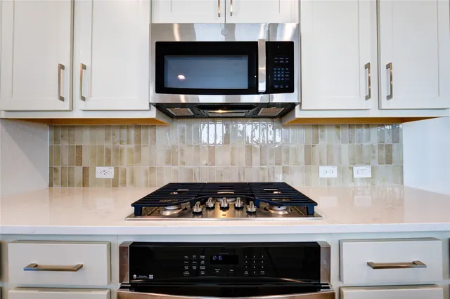 a kitchen with microwave stove and cabinets