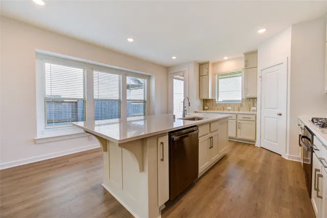 a kitchen with granite countertop a sink a counter top space and stainless steel appliances