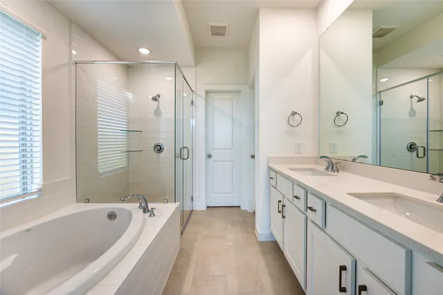 a spacious bathroom with a tub sink shower and mirror
