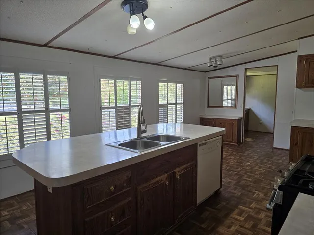 a kitchen with sink refrigerator and large window
