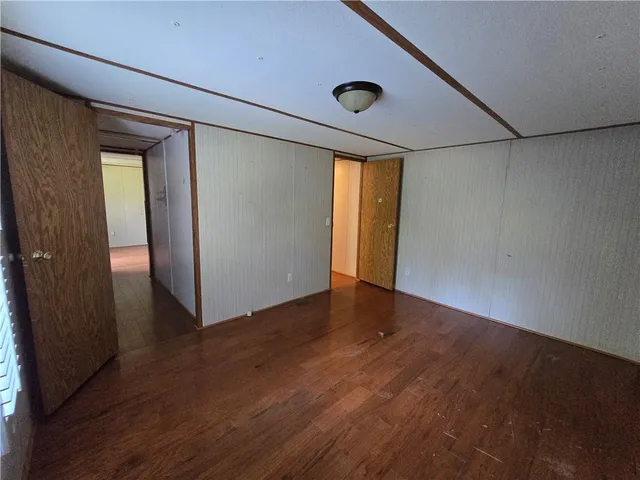 an empty room with wooden floor and closet