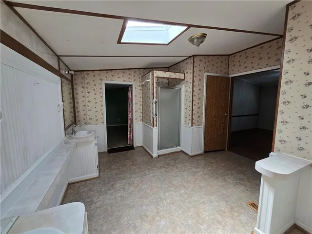 a view of an empty room with closet and a window