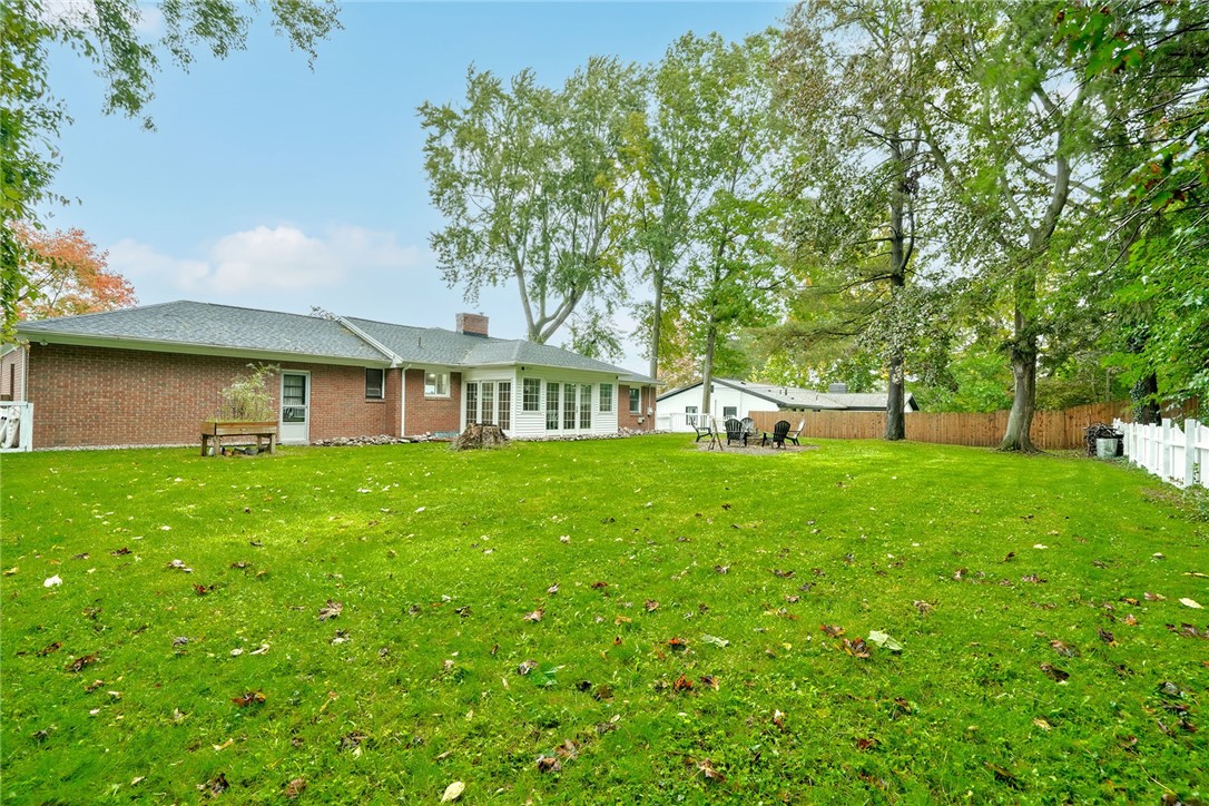 255 Fairport Road East Rochester, NY 14445 - Photo 24 of 26 Mature trees frame a spacious, fully fenced yard behind the brick residence.