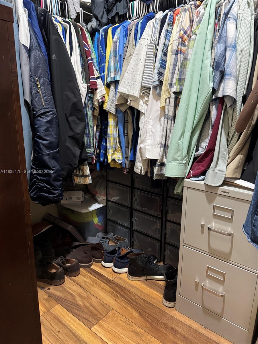 23477 Southwest 112th Place Homestead, FL 33032 - Photo 17 of 49 a view of walk in closet with clothes and shoes