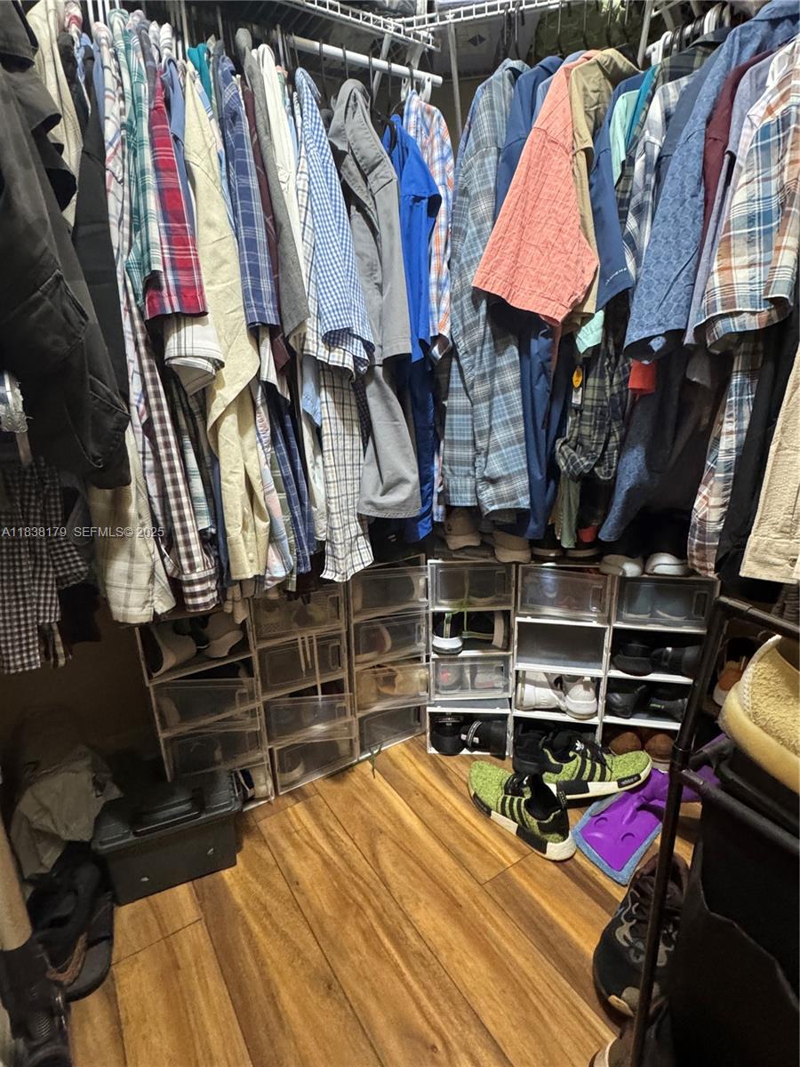 23477 Southwest 112th Place Homestead, FL 33032 - Photo 18 of 49 a view of walk in closet with clothes and shoes