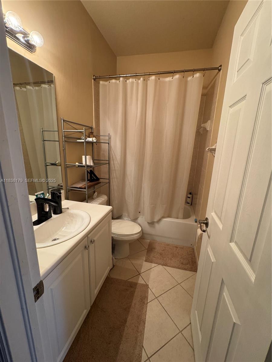 23477 Southwest 112th Place Homestead, FL 33032 - Photo 23 of 49 a bathroom with a sink a toilet a mirror and shower curtain