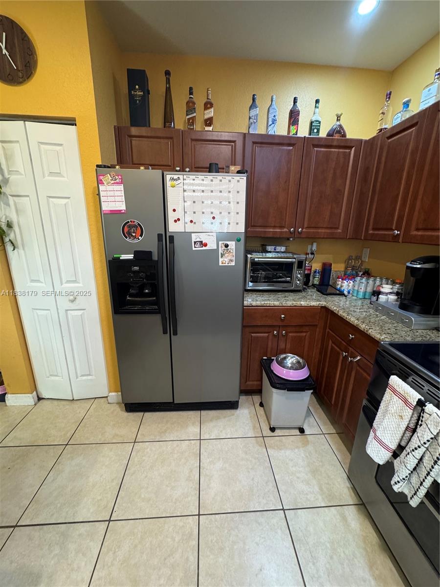 23477 Southwest 112th Place Homestead, FL 33032 - Photo 6 of 49 a kitchen with a refrigerator and a stove