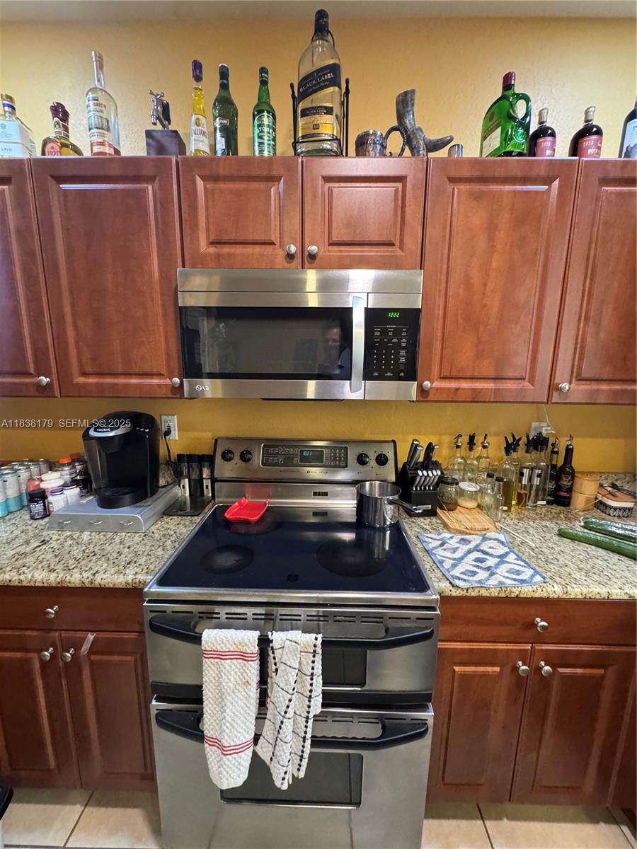 23477 Southwest 112th Place Homestead, FL 33032 - Photo 7 of 49 a kitchen with granite countertop stainless steel appliances stove and cabinets