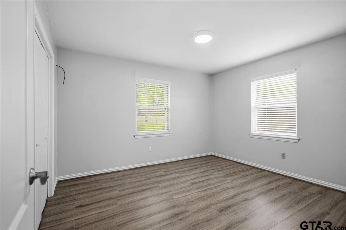 701 Georgia Street Lindale, TX 75771 - Photo 22 of 37 an empty room with wooden floor and windows