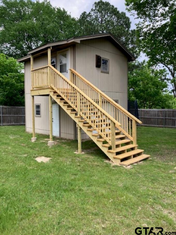 701 Georgia Street Lindale, TX 75771 - Photo 31 of 37 a backyard of a house with wooden deck and stairs