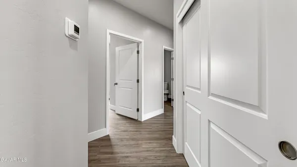 an empty room with wooden floor and ceiling fan